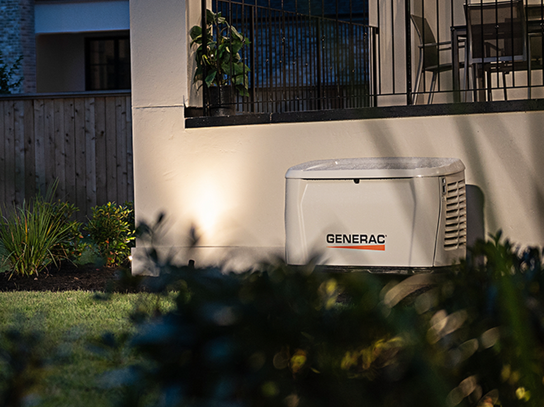Generac Guardian standby generator installed beside a home at dusk