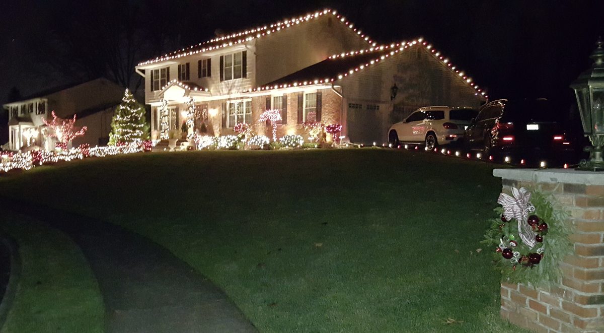 Holiday lights along driveway and porch