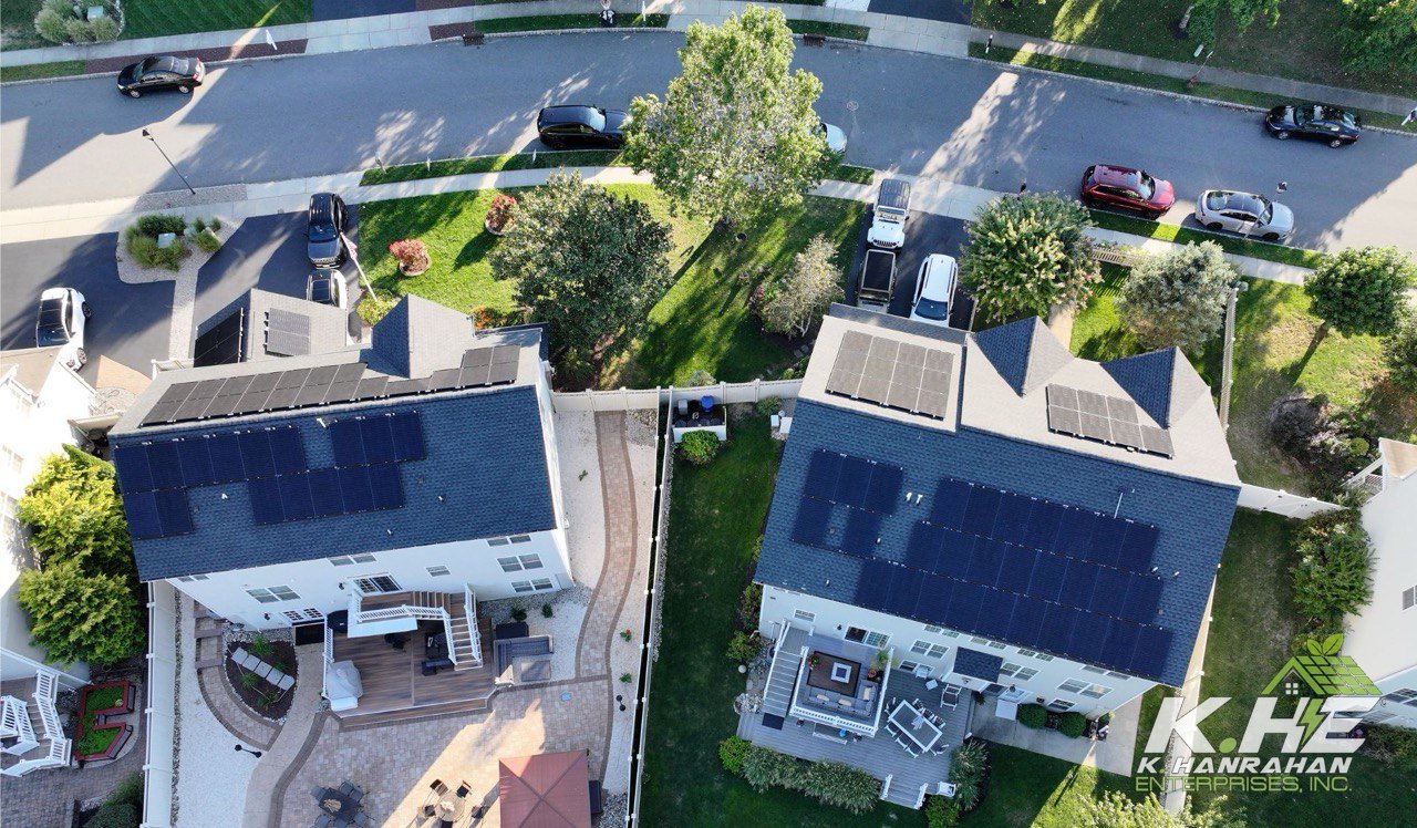 Drone view of two homes with full rooftop solar arrays — KHE install